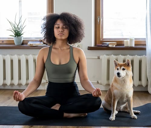 woman meditates with her dog